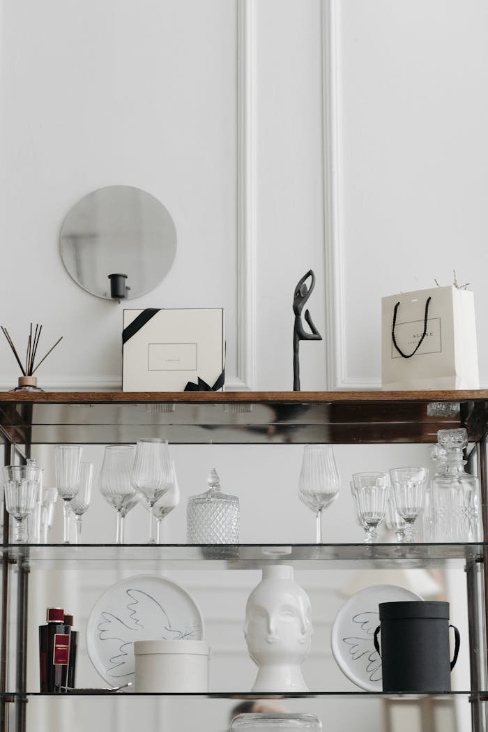 A stylish display of glassware and home decor on modern shelves in a chic interior.